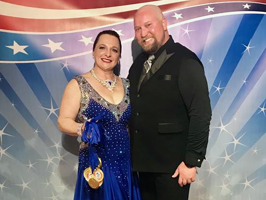 Chris Kuznar and her dancing instructor with the medals they won in a competition