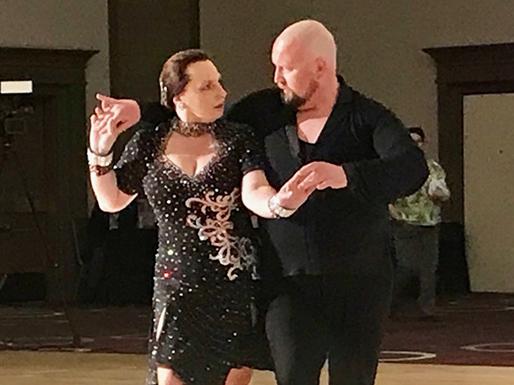 Chris Kuznar is dancing with her instructor during a competition