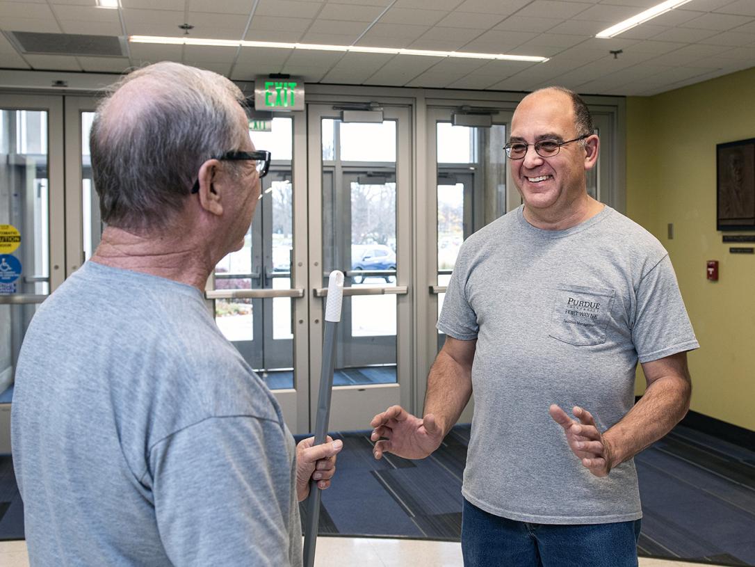Jerry McCagg chats with a coworker in Kettler Hall.