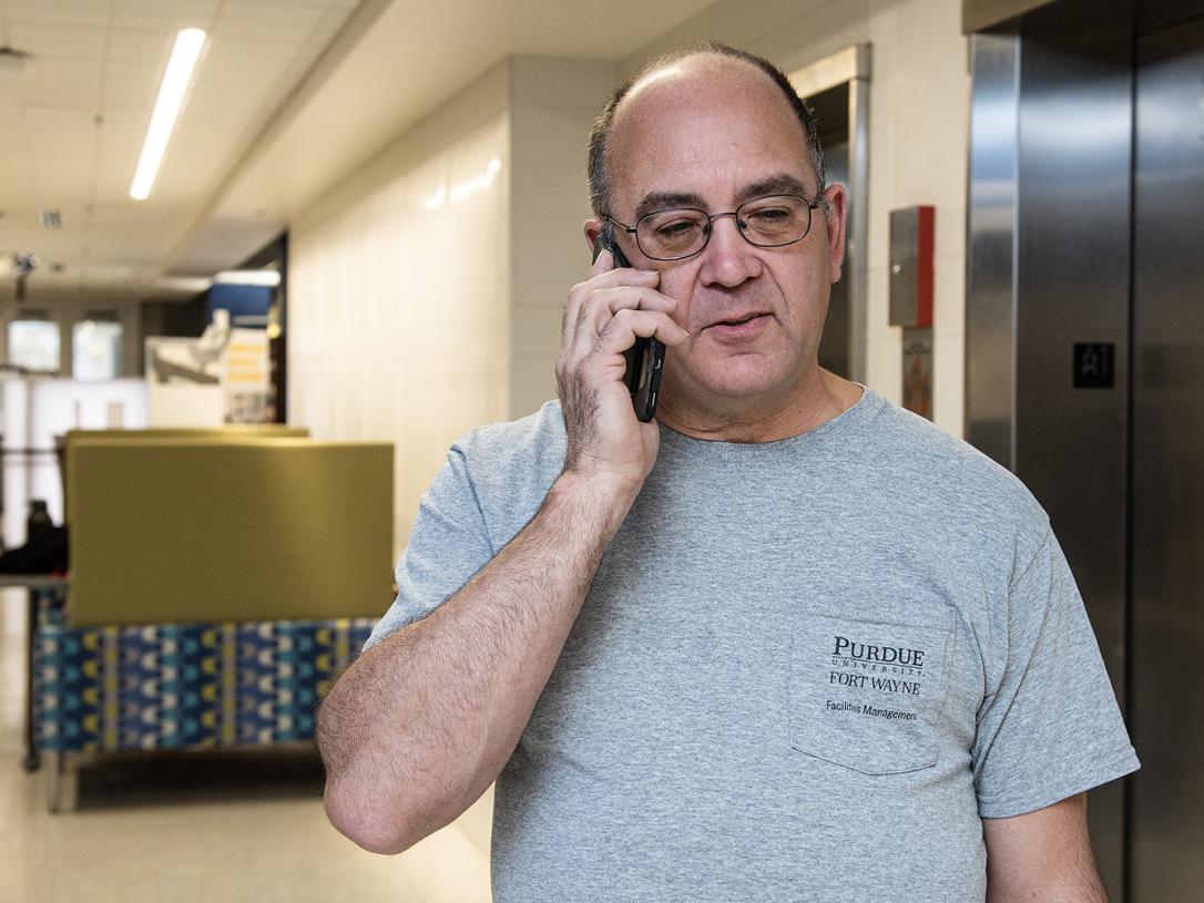 Jerry McCagg is using his phone in Kettler Hall