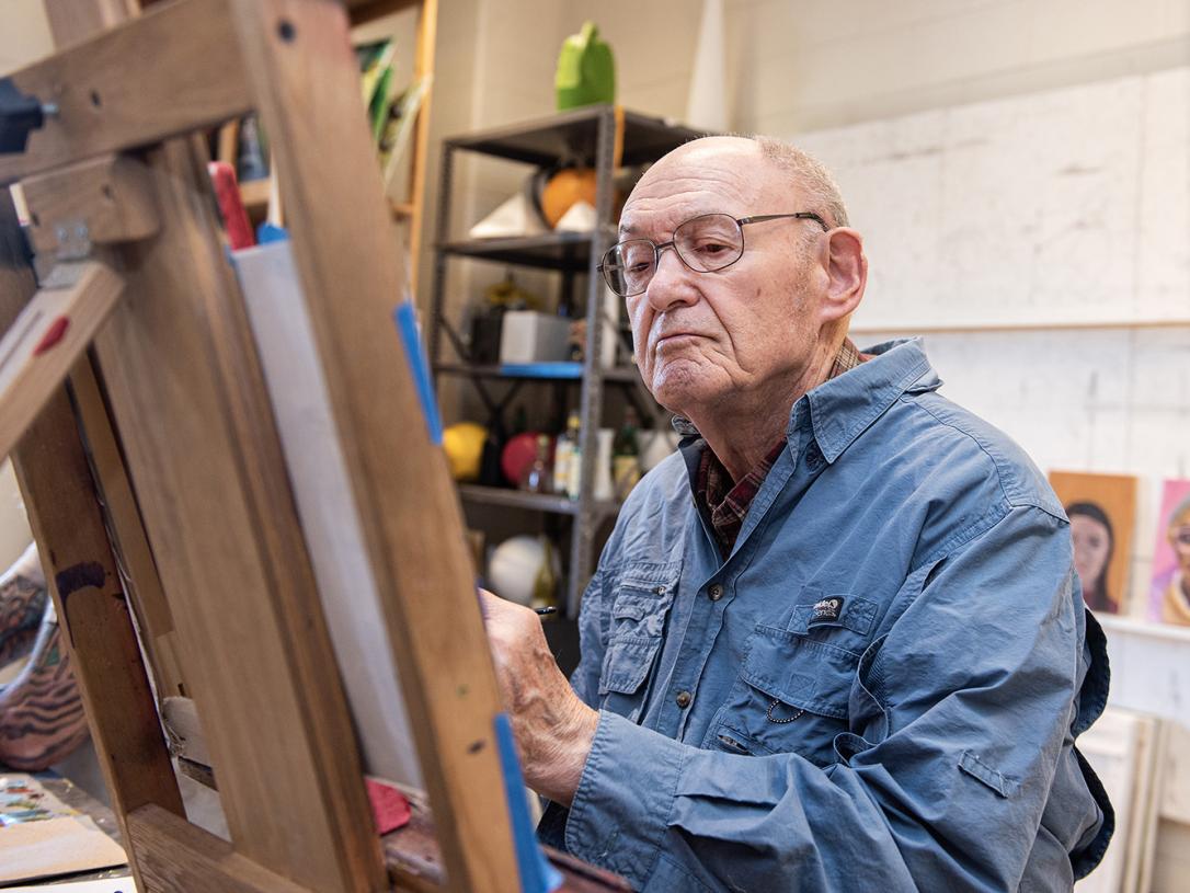 Alan Grinsfelder is behind an easel