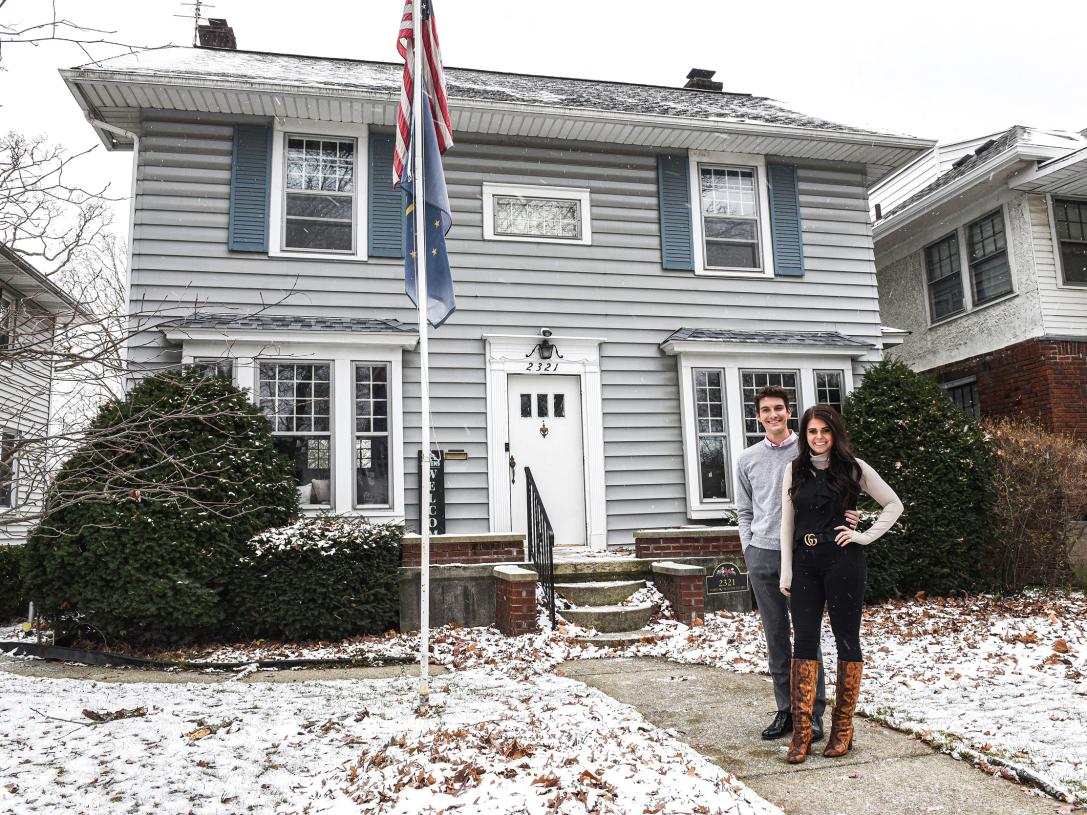 Julia Green and her husband are standing in front of their home