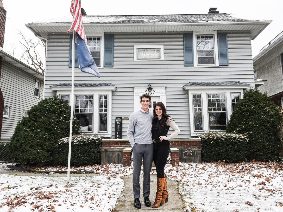 Julia Green and her husband are standing in front of their home