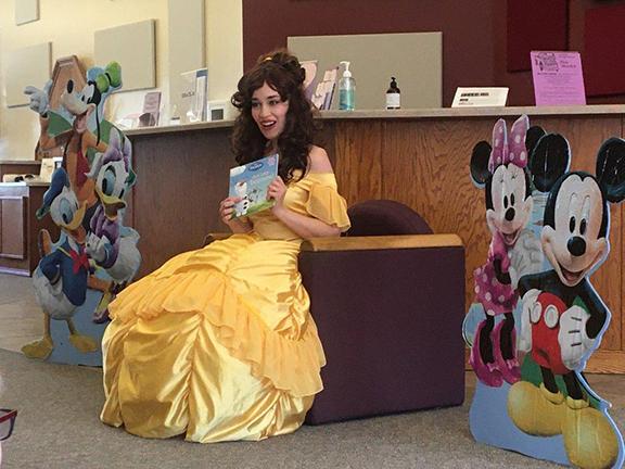 Chantelle Huebner reading a book while dressed as Belle