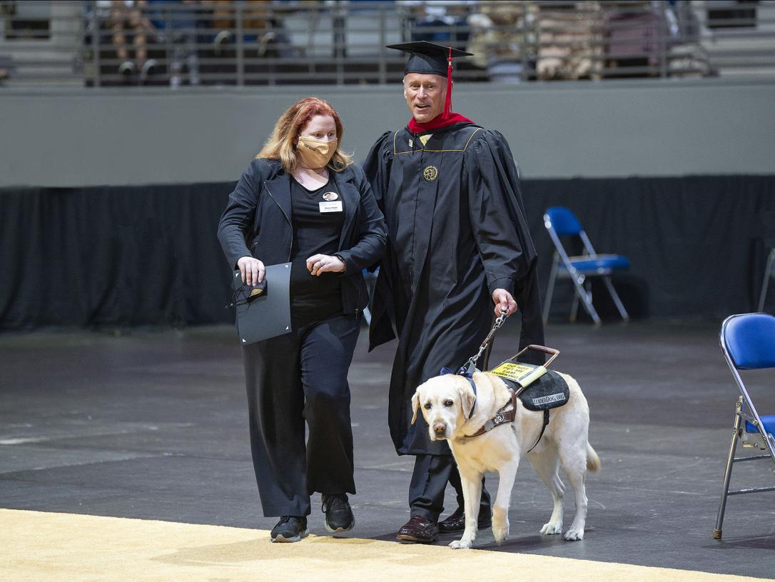 Jim Platzer and his leader dog, Maggie, at the 2021 commencement ceremony