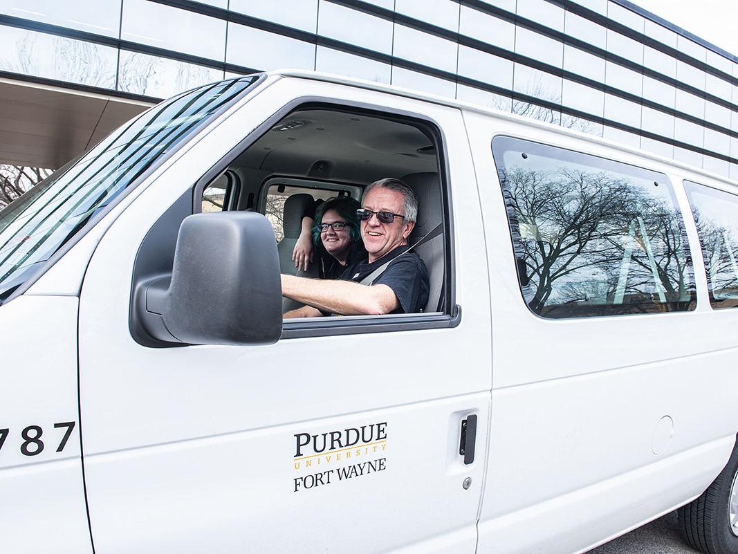 A driver is dropping off students on campus.