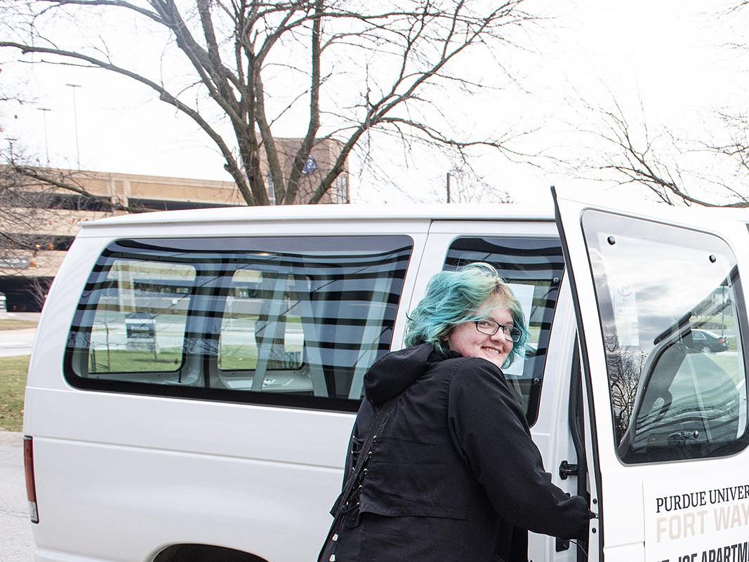 A student is entering a shuttle van at Purdue Fort Wayne