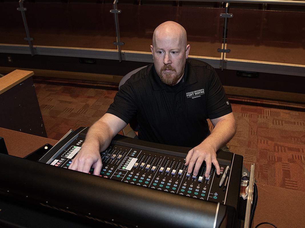 Tom Auer is working behind a sound board 