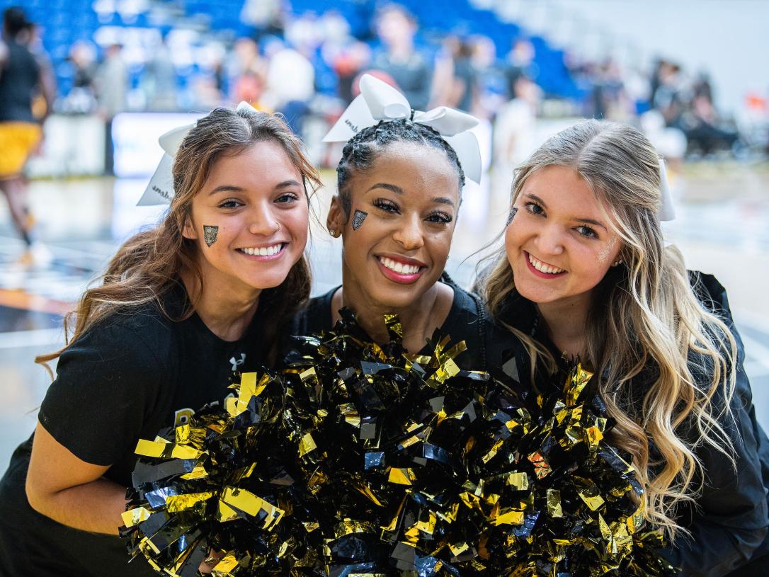 Three PFW cheerleaders are smiling