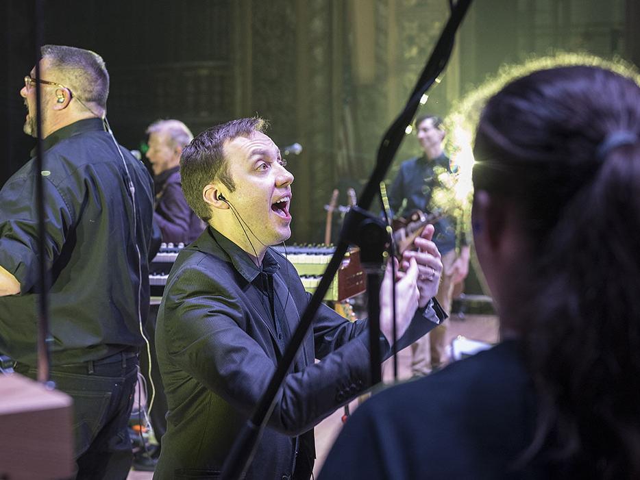 William Sauerland leads the choir at a Pink Droyd concert in the Embassy Theatre.
