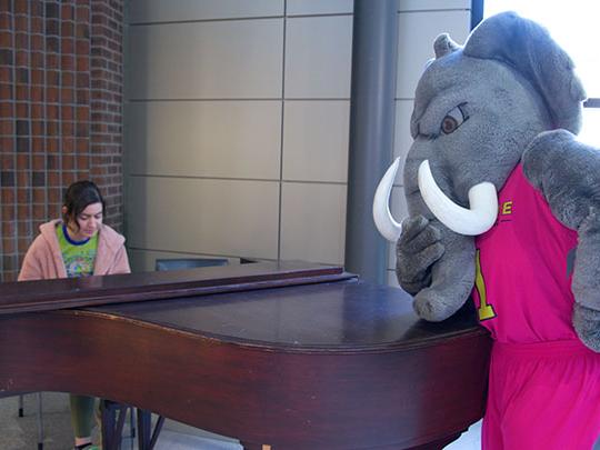 Don the mastodon is listening to Fiona McKinney play the piano