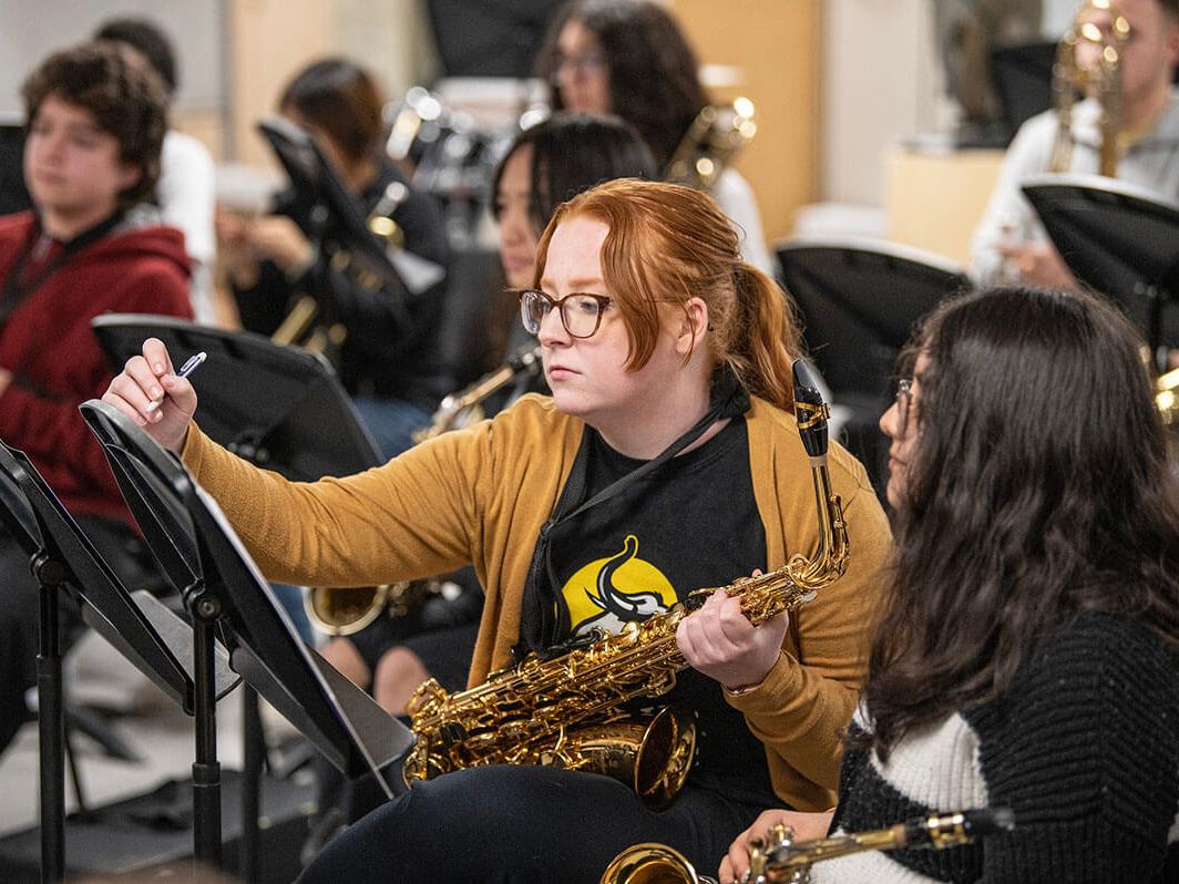 Music education student Lizi Brumbaugh teaches a middle school saxophone player