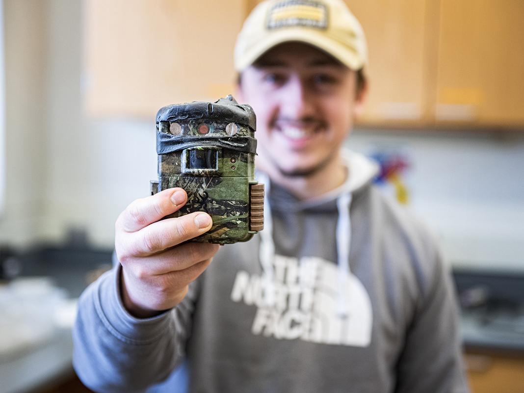 Carsten White displays a camera used to survey small mammals.
