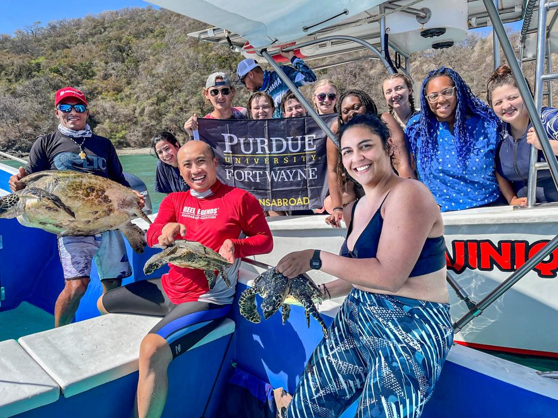 PFW marine biology students and faculty display turtles on a boat