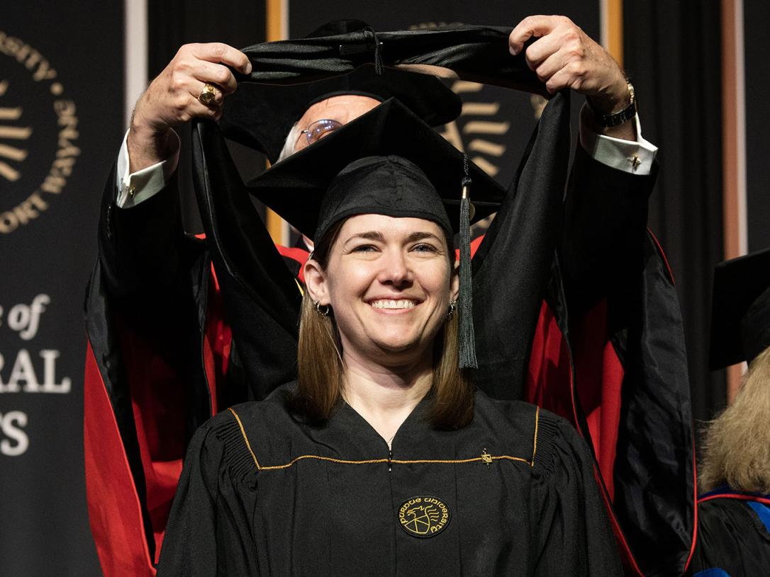 A smiling graduate at PFW’s 2023 Commencement.