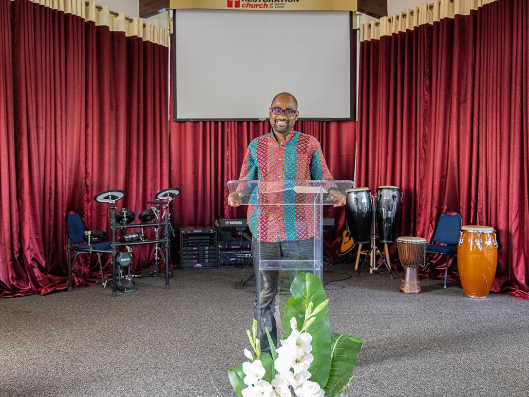 Francois Mikobi is standing at the lectern in church.