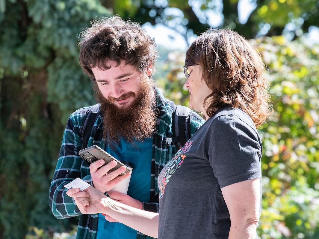 A student gets a phone number from a business card.