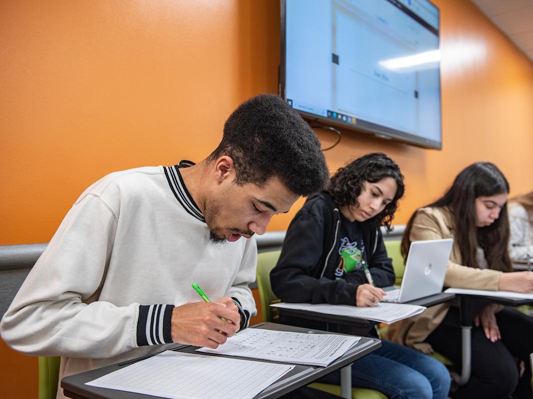 Students writing and working on assignments in class.
