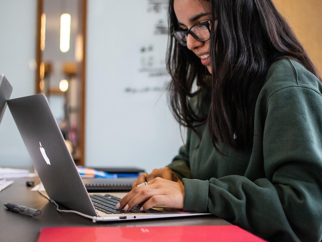 A student works on a laptop.
