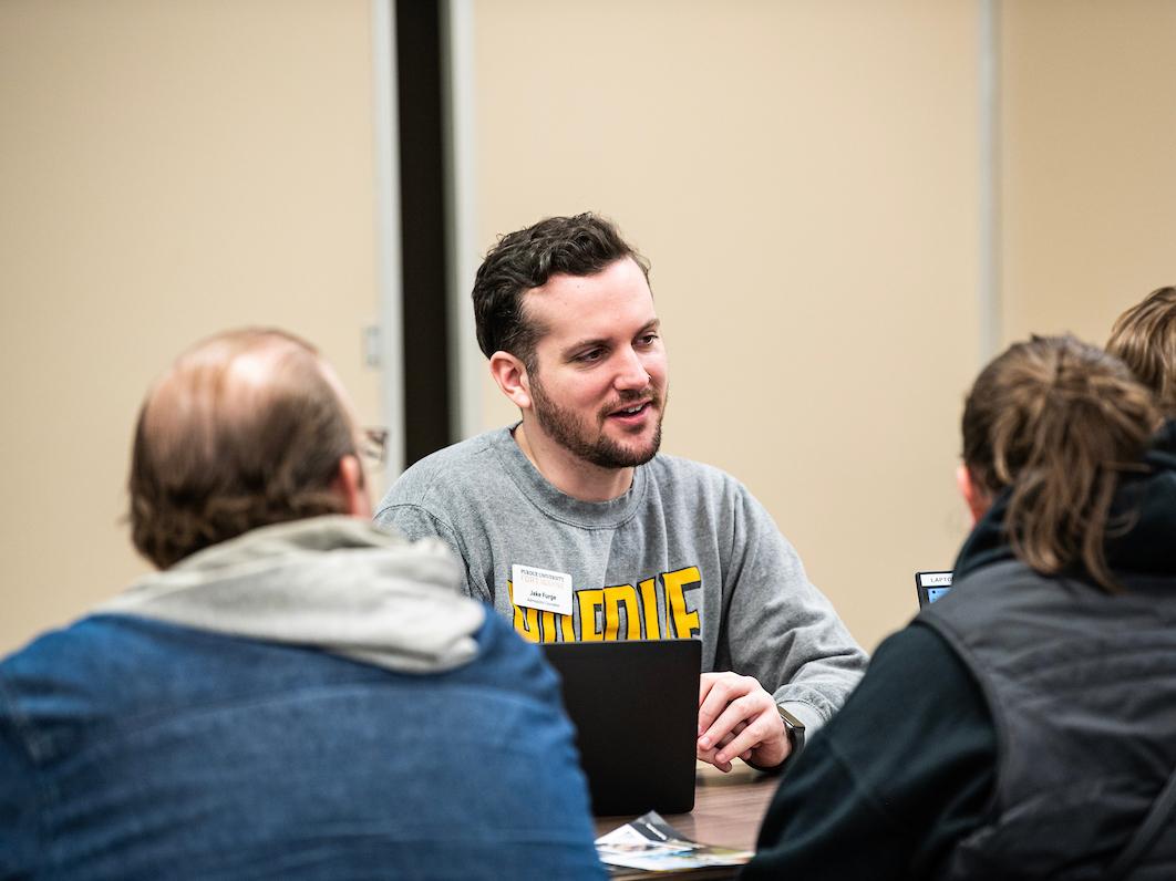 Student worker talking with prospective students and parents.
