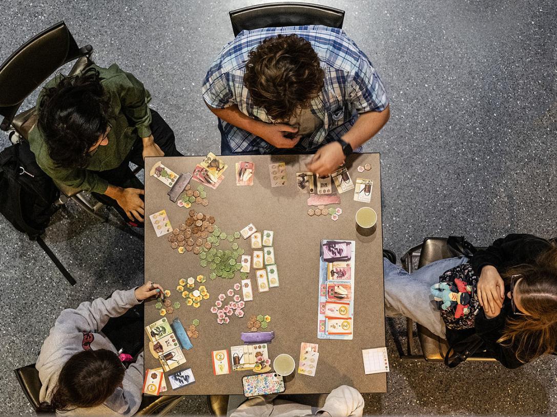 Four people are playing a board game