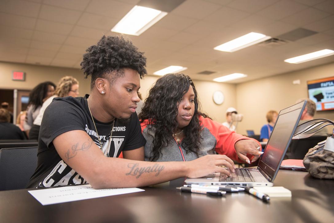A student and parent fill out FAFSA forms at PFW.