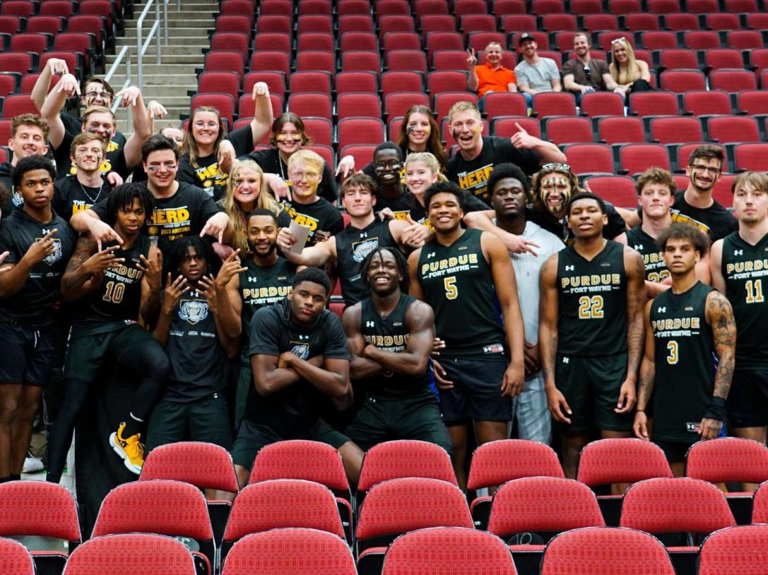 Group photo of The Herd with members of the PFW men's basketball team.
