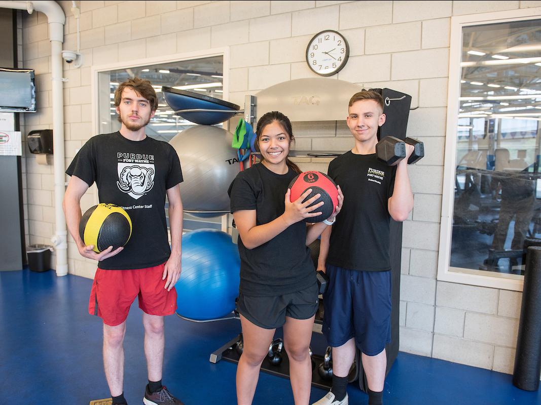 Two students holding medicine balls