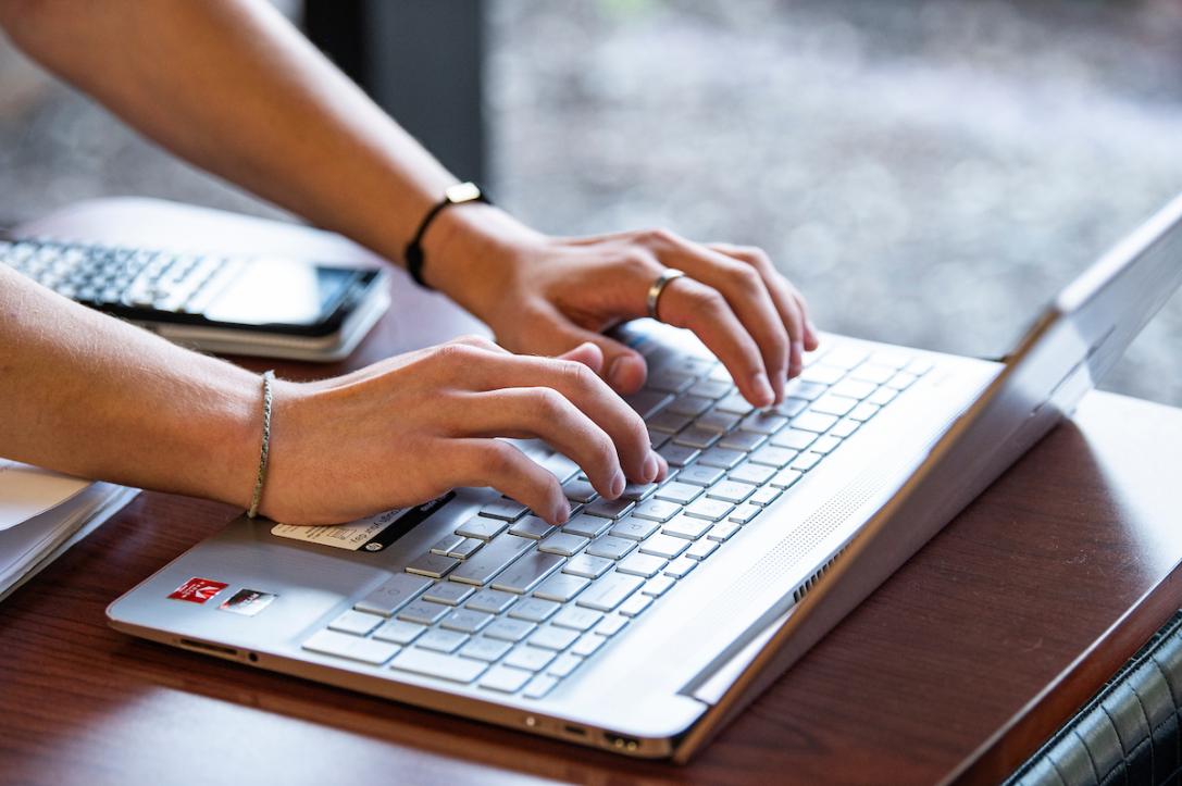 Student typing on a laptop.