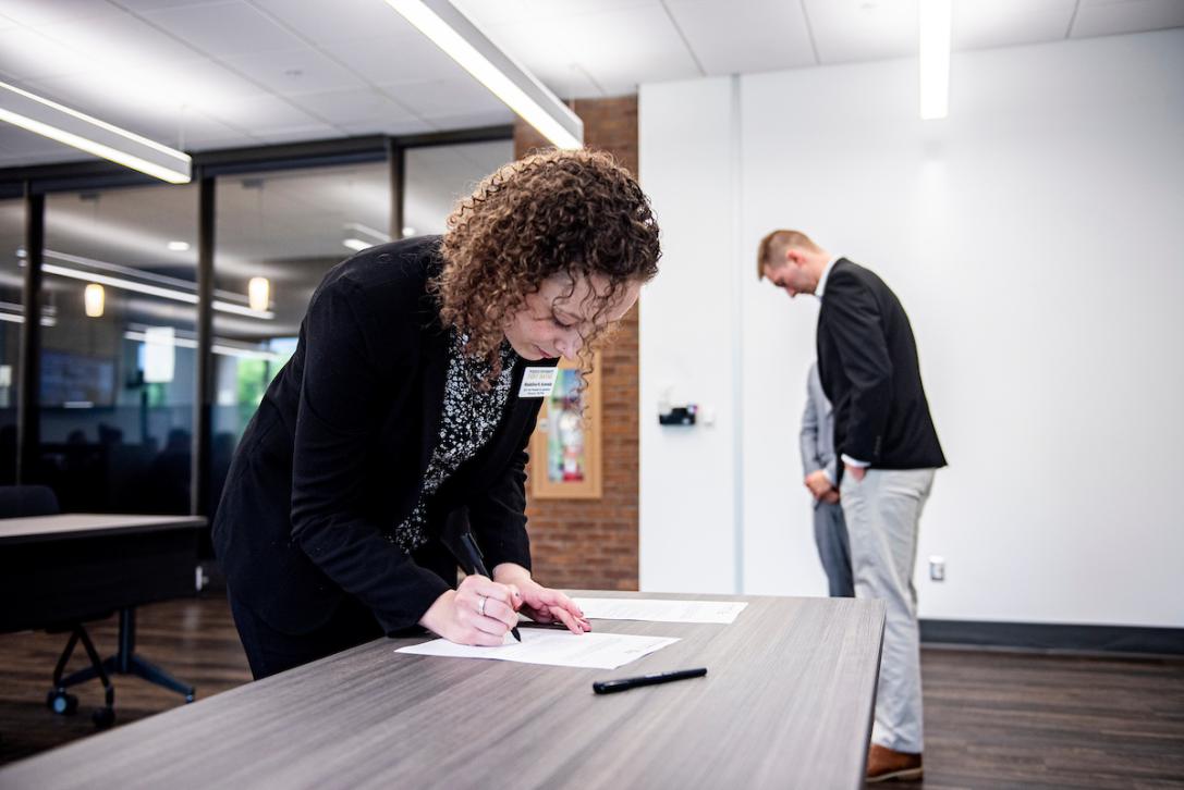 Student signing form on SGA Inauguration Day.