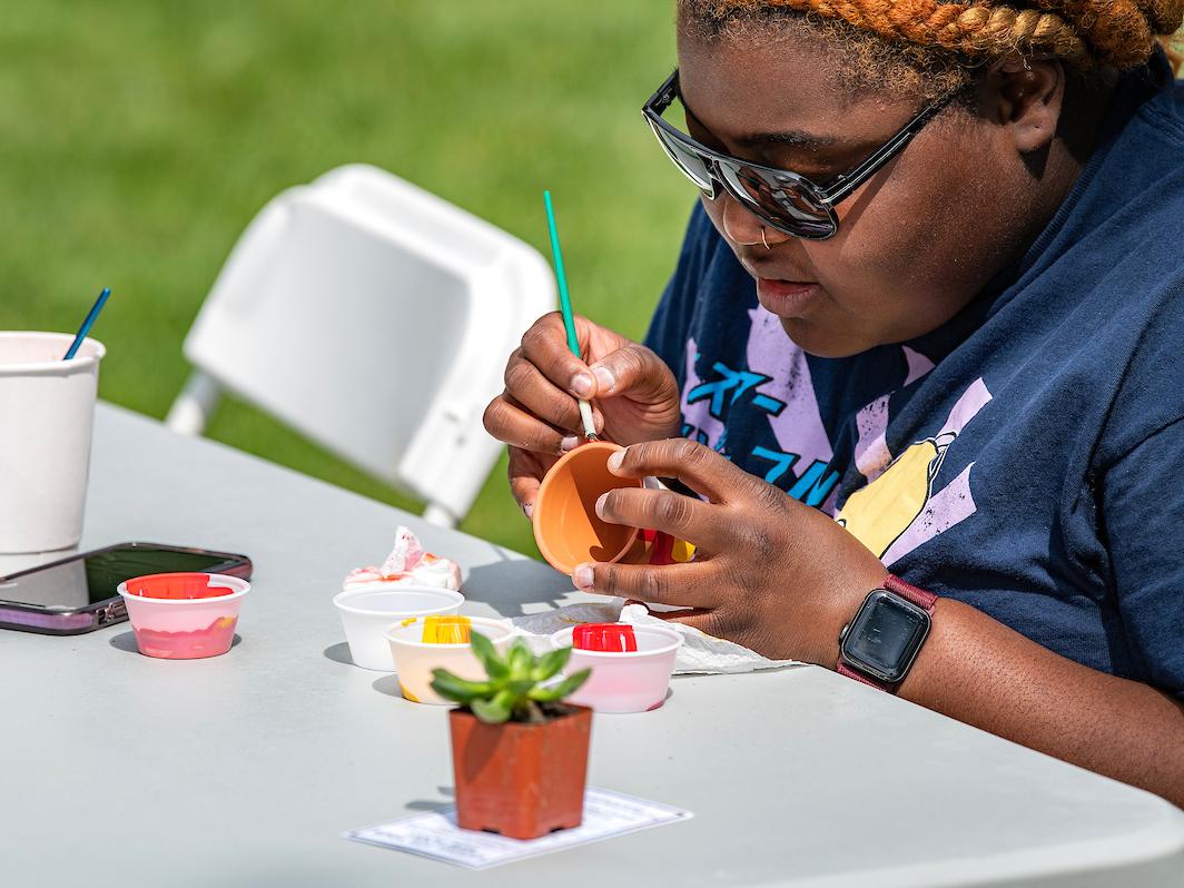 Student painting a planter pot