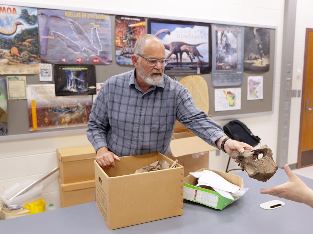Ben Dattilo, professor of geology, places mastodon bones in a box for transport.