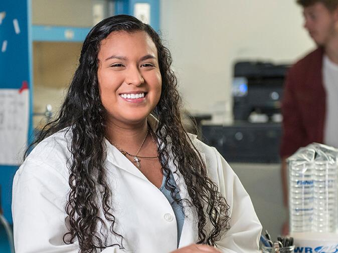 Student standing in a lab coat
