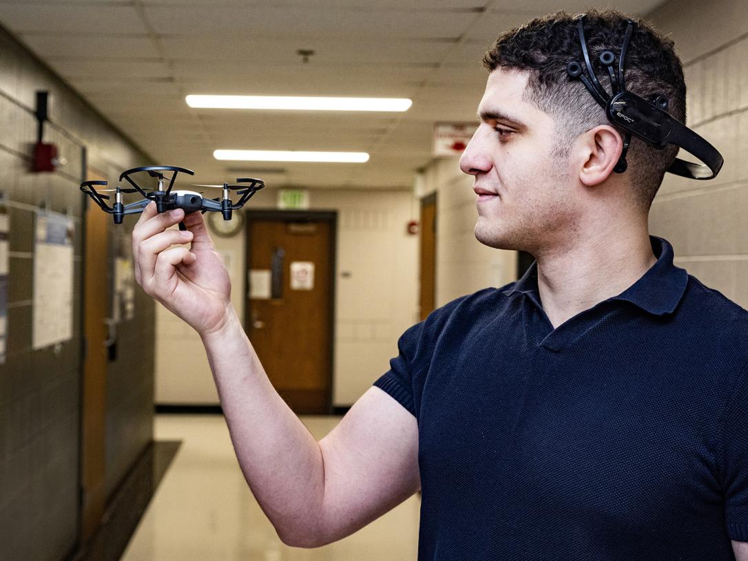 Abdelrahman Gad inspects a small, four-propeller drone.