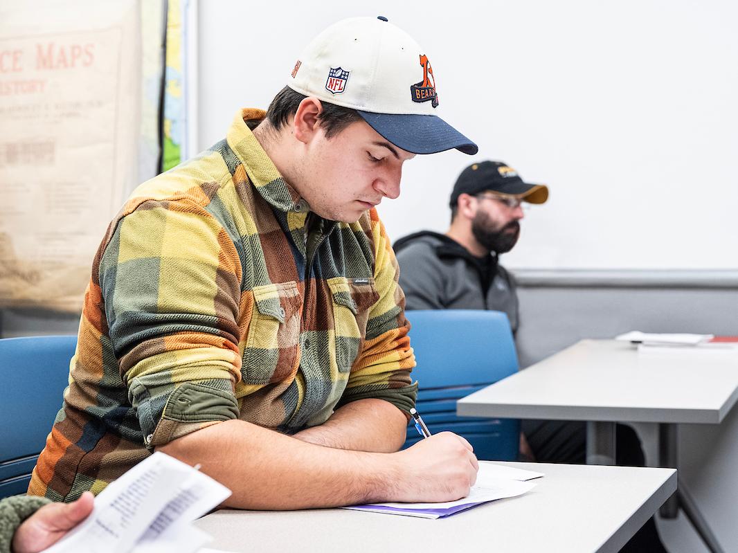 Student reading a paper in class