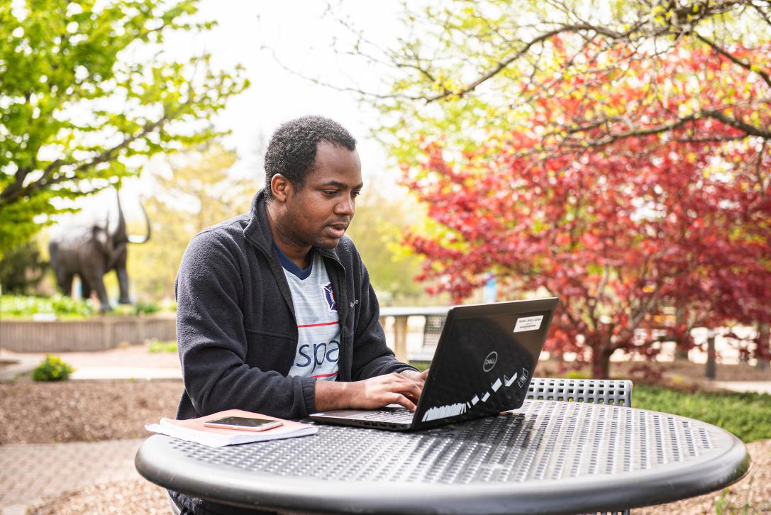 Student watching an educational video on a laptop.