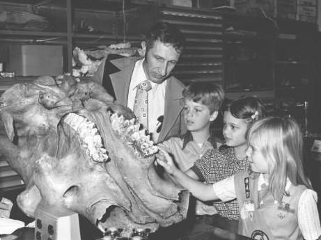 Professor Jack Sunderman shows the mastodon skull with its massive teeth to three unidentified school children in 1978.