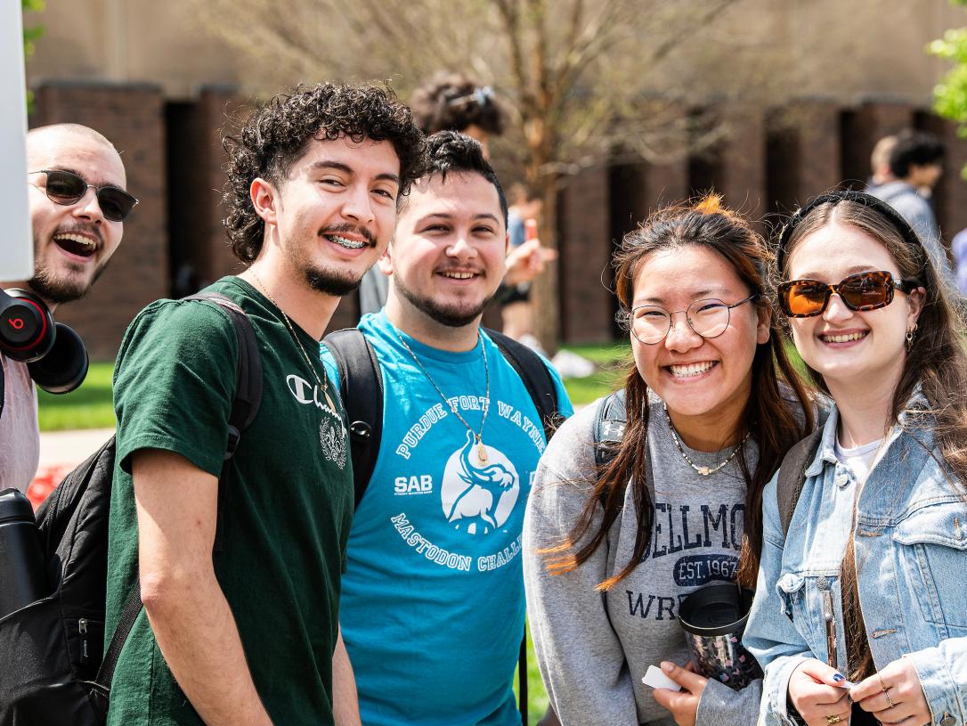 Students smiling at a tie-dye event on campus.