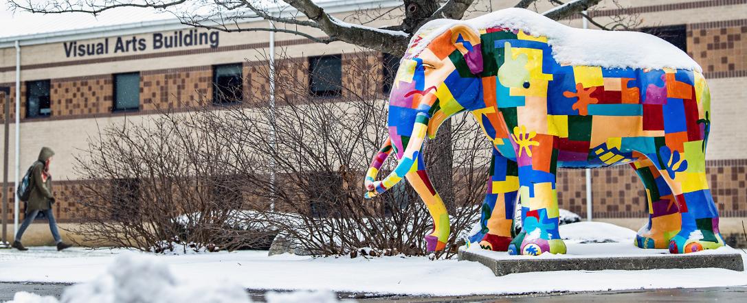 Colorful Mastodon greets students at the entrance of the Visual Arts Building.