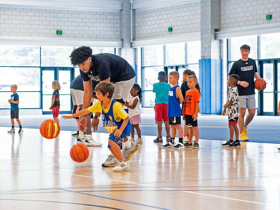 A PFW athlete is teaching at a children's basketball camp