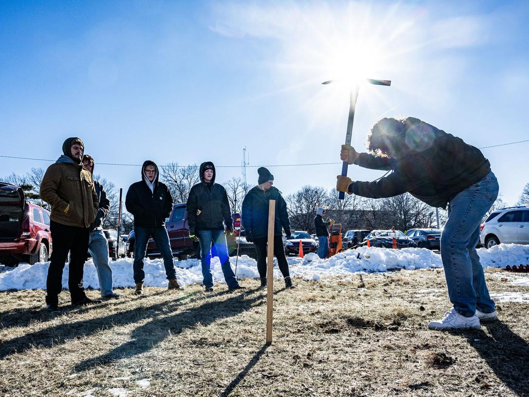 Civil Engineering students are using a pickaxe to take a soil sample
