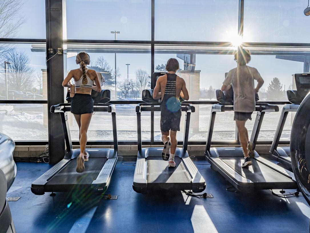 Three students running on treadmills
