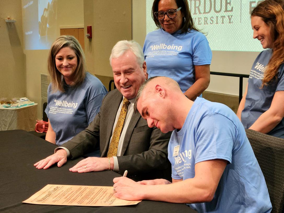 Eric Manor, associate chief of campus and community wellbeing, adds his signature to the charter.