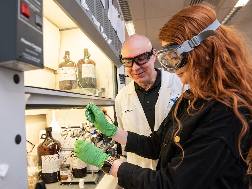 Professor Stevenson and a student working in a chem lab.