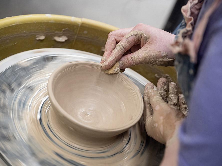 Turning a bowl on a pottery wheel.