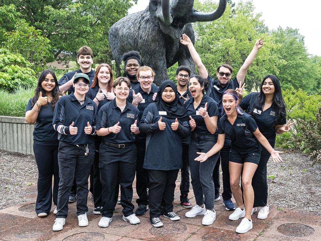 Student coaches in front of the mastodon statue