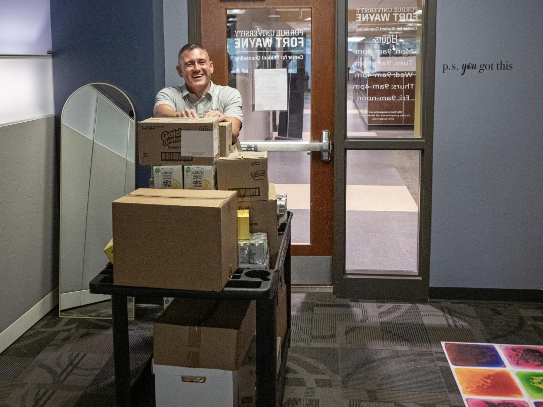 Eric Manor is moving items into the new pantry location in Kettler Hall