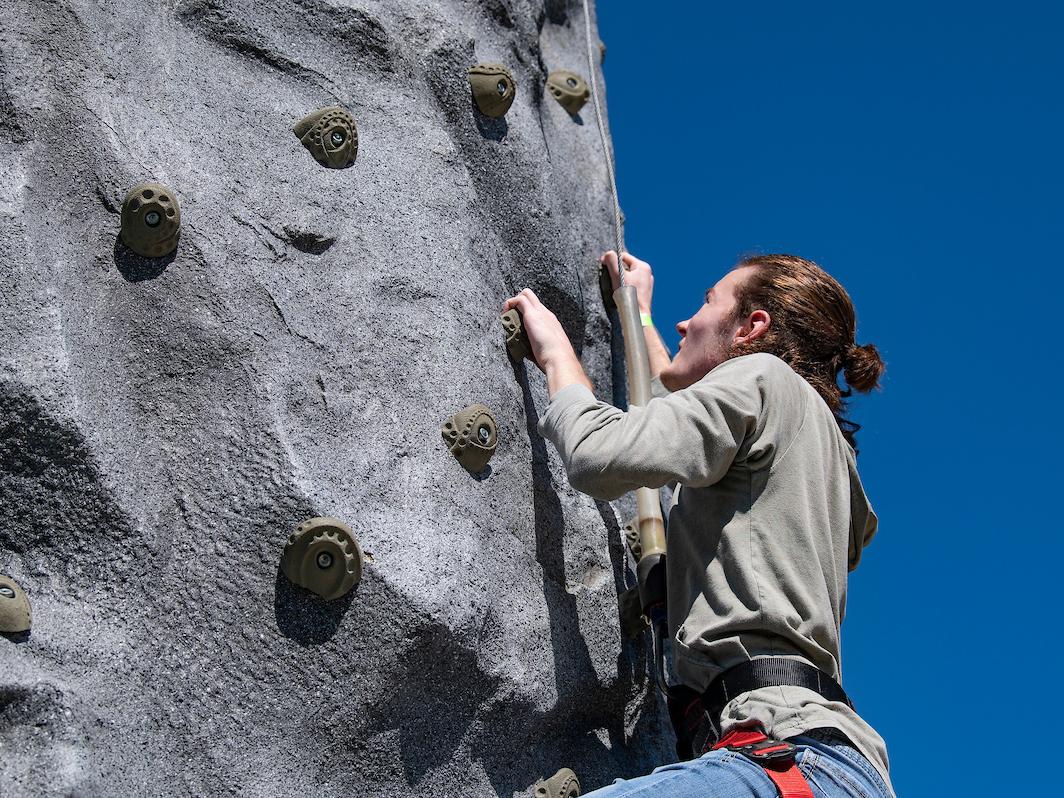 A student is climbing a rock wall