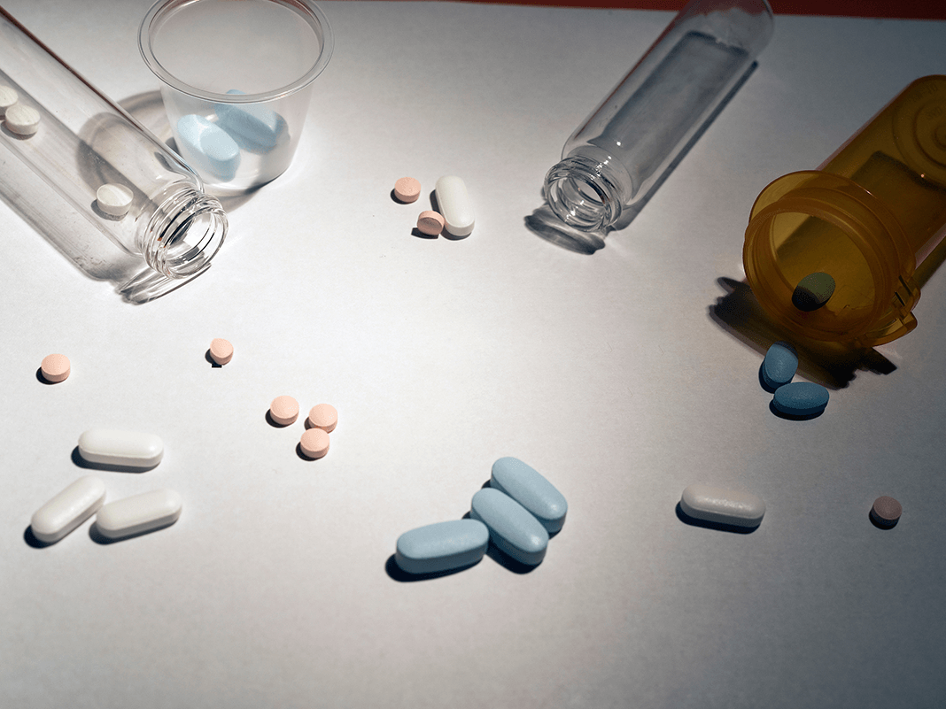 Several pills surrounded by vials