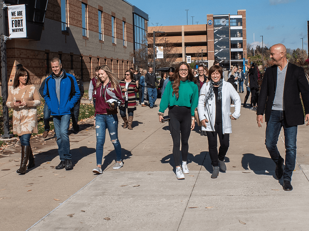 Students and their families are walking down the sidewalk
